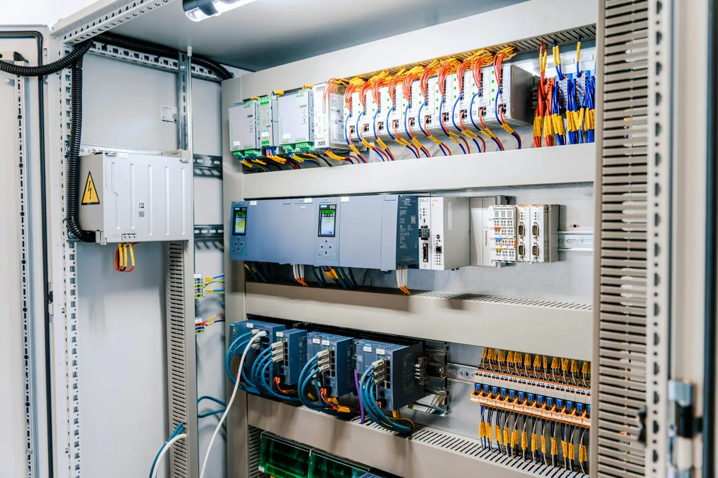 Open industrial electrical control panel with wiring and modules