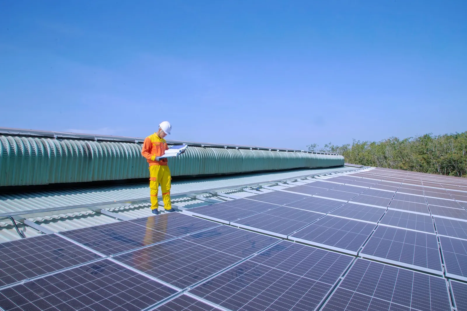 Technician walking across a rooftop solar array